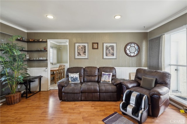 living room with ornamental molding and light hardwood / wood-style floors