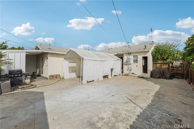 rear view of house with a patio area and a storage unit