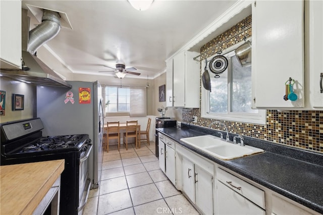 kitchen featuring white cabinets, light tile patterned flooring, sink, and stainless steel gas range oven