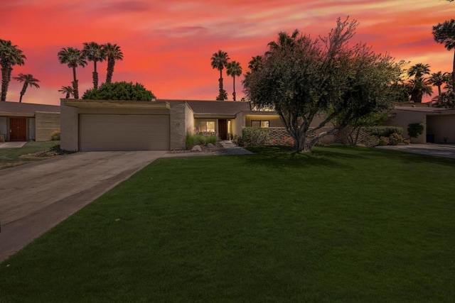 view of front of home with a garage and a lawn