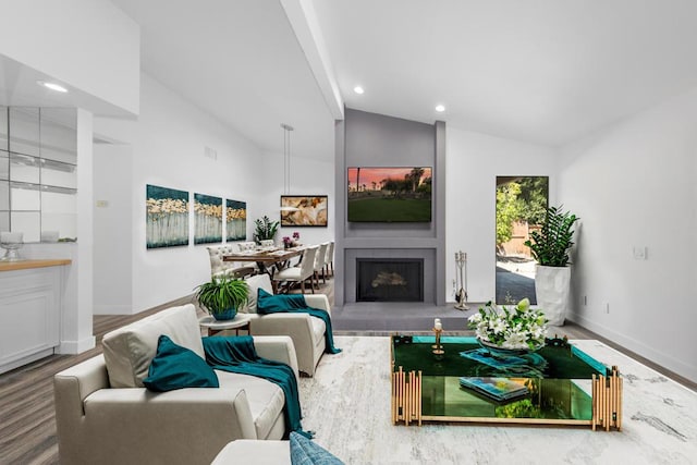 living room with a tiled fireplace, hardwood / wood-style floors, and lofted ceiling