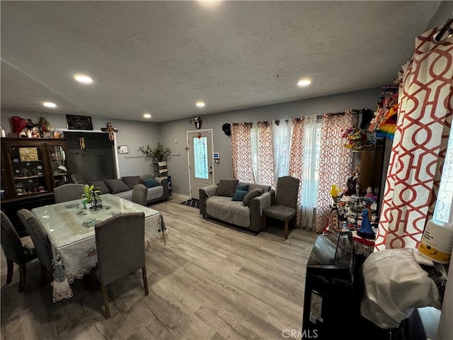 dining area with a textured ceiling and light wood-type flooring