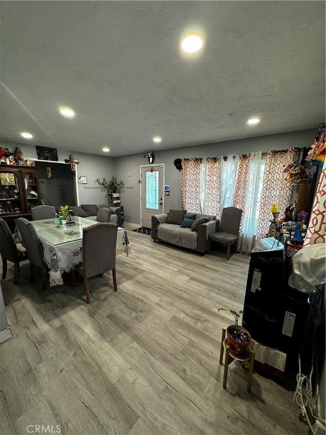 dining space with a textured ceiling, hardwood / wood-style floors, and plenty of natural light