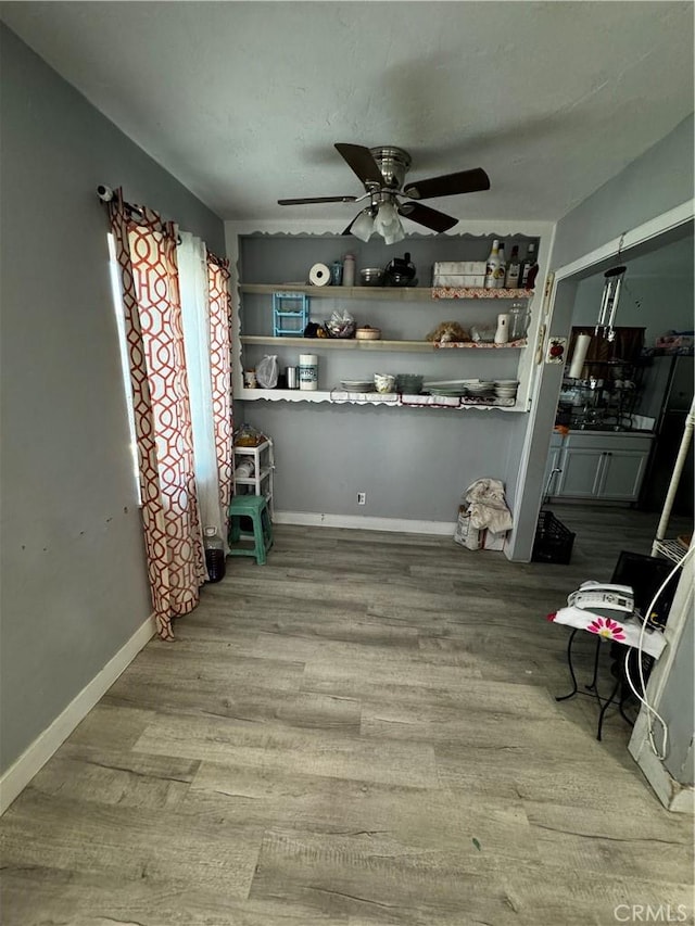 unfurnished dining area featuring ceiling fan and light wood-type flooring