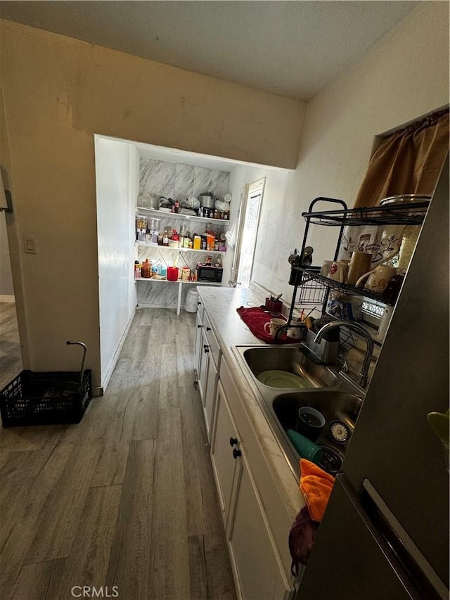 kitchen featuring white cabinets, hardwood / wood-style flooring, and sink