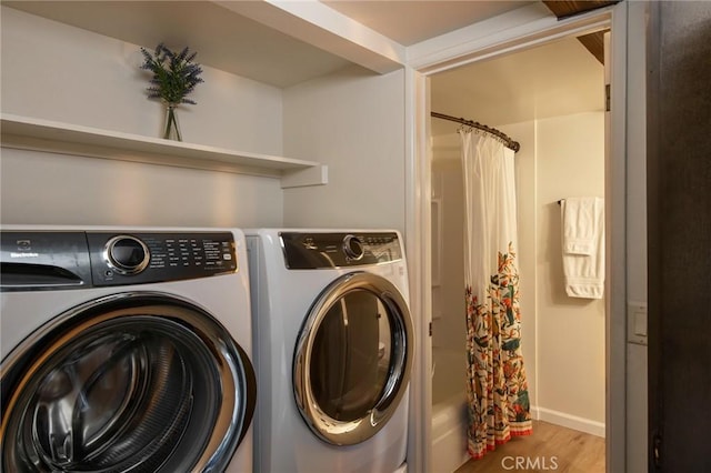 washroom with hardwood / wood-style flooring and independent washer and dryer