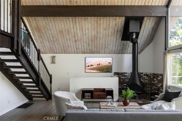 living room featuring a wood stove, a wealth of natural light, wood ceiling, and wood-type flooring