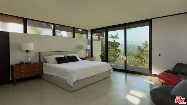 bedroom with access to outside, floor to ceiling windows, a mountain view, and concrete floors