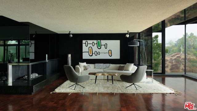 living room with hardwood / wood-style floors, floor to ceiling windows, and a textured ceiling