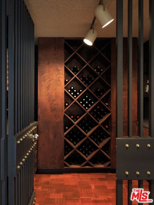 wine room with a textured ceiling and hardwood / wood-style flooring