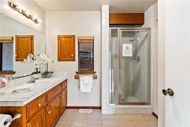 bathroom featuring vanity and an enclosed shower