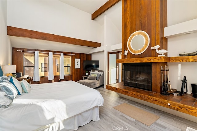 bedroom featuring beamed ceiling, hardwood / wood-style flooring, and high vaulted ceiling