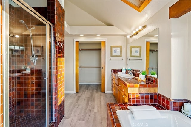 bathroom featuring vanity, lofted ceiling, hardwood / wood-style flooring, and independent shower and bath