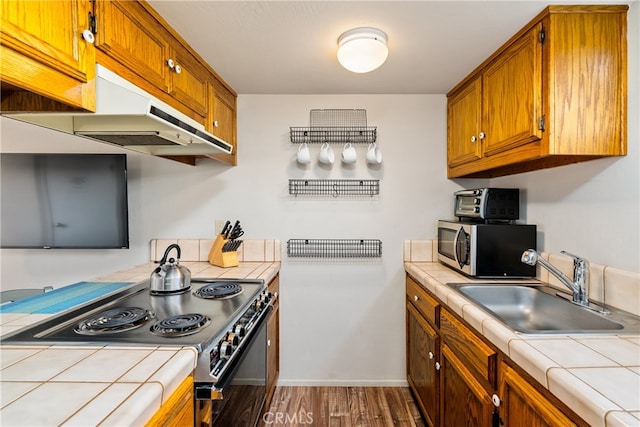 kitchen featuring tile countertops, black / electric stove, dark wood-type flooring, and sink