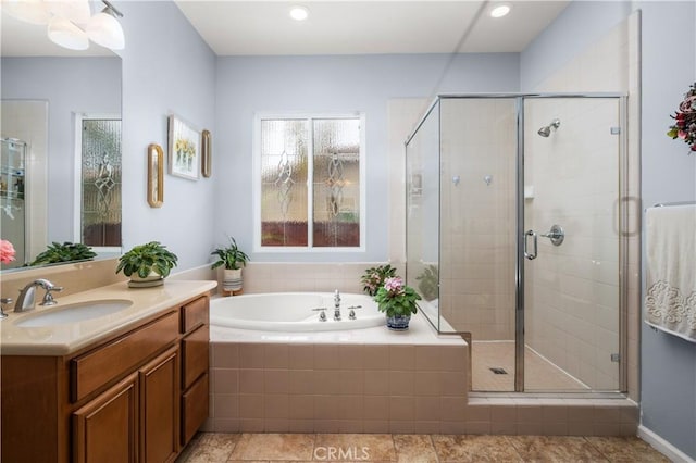 bathroom with plus walk in shower, tile patterned flooring, and vanity