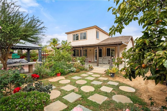 back of property featuring a gazebo and a patio