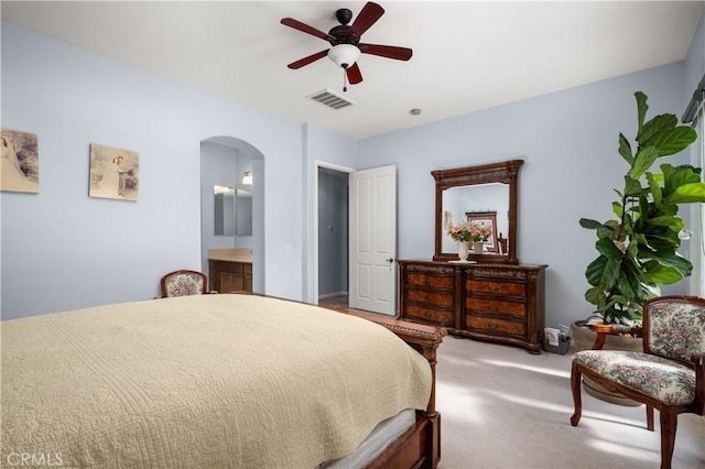 carpeted bedroom with ceiling fan and ensuite bath