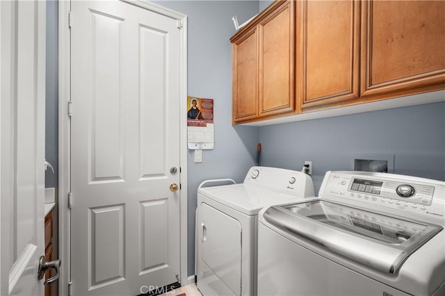 clothes washing area with cabinets and independent washer and dryer