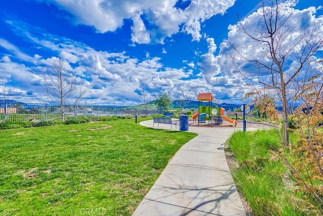 view of home's community featuring a yard and a playground