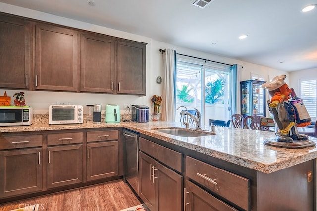 kitchen with sink, light stone countertops, dark brown cabinetry, and light hardwood / wood-style floors