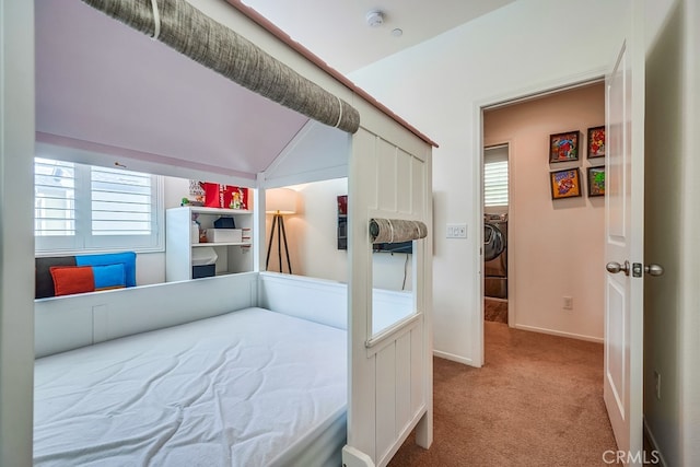 carpeted bedroom featuring vaulted ceiling and washer / clothes dryer