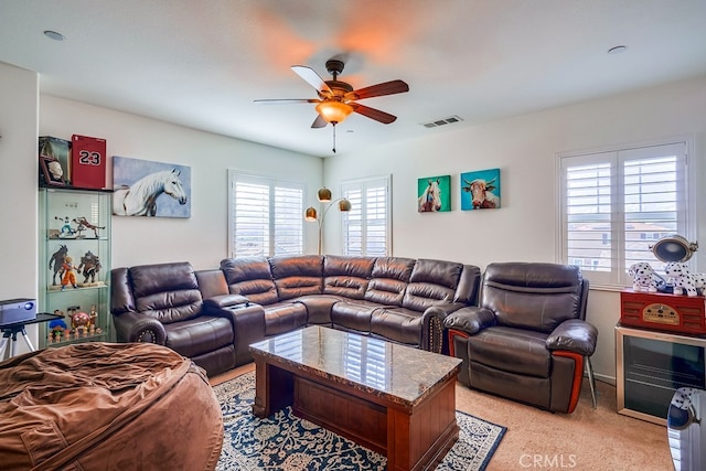 living room with ceiling fan, light carpet, and a wealth of natural light