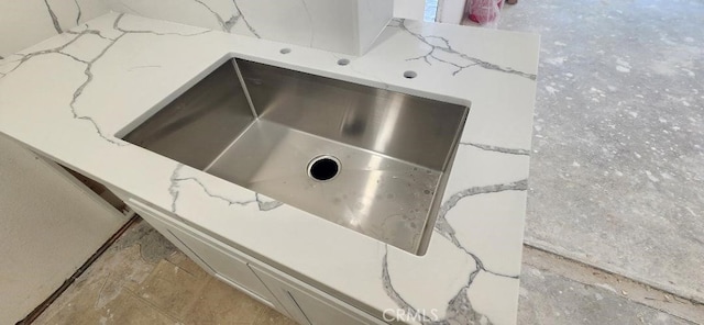 interior details with light stone counters and a sink