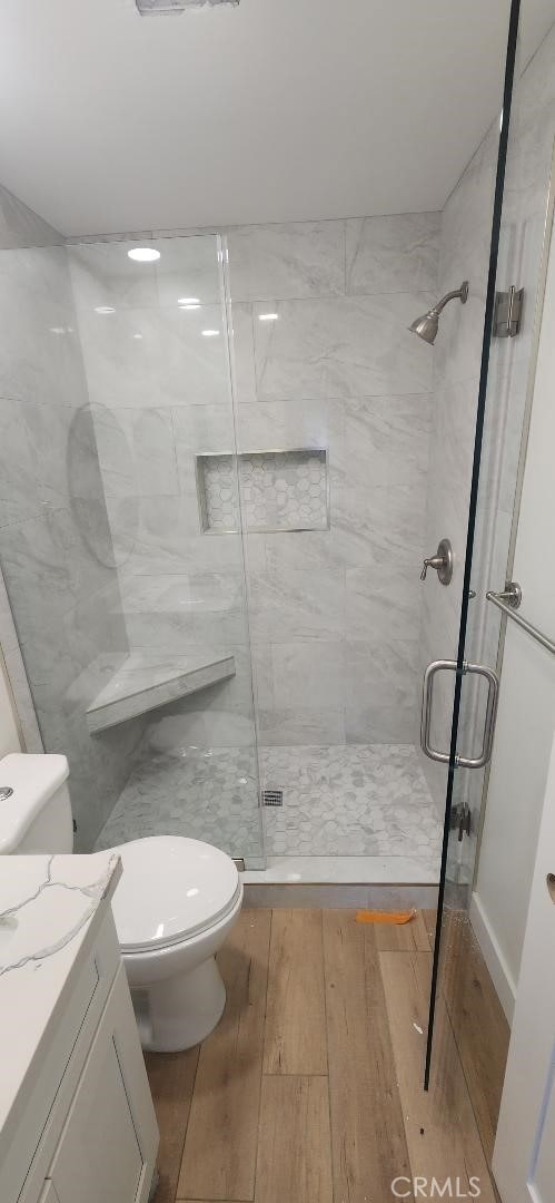 2511 W Sunflower Ave Unit P6, Santa Ana, CA 92704 - full bathroom featuring toilet, a shower stall, vanity, and wood finished floors