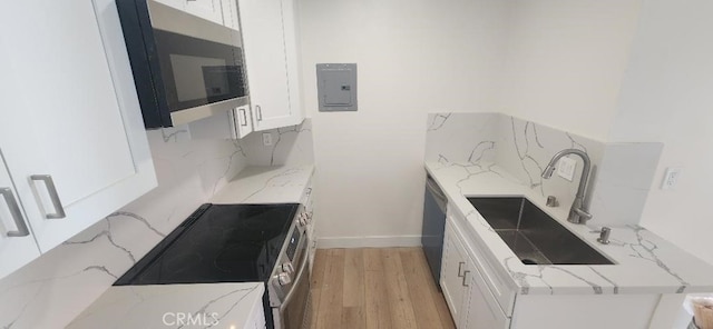 2511 W Sunflower Ave Unit P6, Santa Ana, CA 92704 - kitchen featuring a sink, backsplash, appliances with stainless steel finishes, and white cabinetry