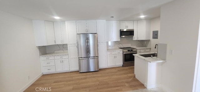 2511 W Sunflower Ave Unit P6, Santa Ana, CA 92704 - kitchen with white cabinets, decorative backsplash, stainless steel appliances, light wood finished floors, and a sink