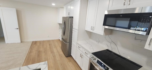 2511 W Sunflower Ave Unit P6, Santa Ana, CA 92704 - kitchen with stainless steel appliances, light wood-type flooring, white cabinetry, and light stone counters