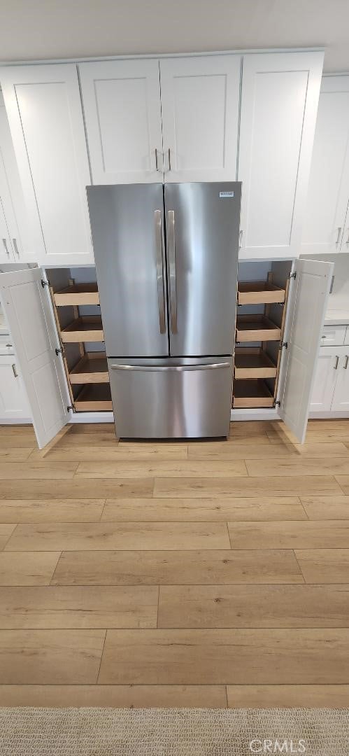 2511 W Sunflower Ave Unit P6, Santa Ana, CA 92704 - room details featuring light wood finished floors, freestanding refrigerator, and white cabinetry