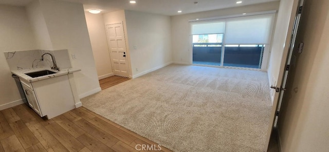 2511 W Sunflower Ave Unit P6, Santa Ana, CA 92704 - interior space featuring baseboards, light carpet, recessed lighting, light wood finished floors, and a sink
