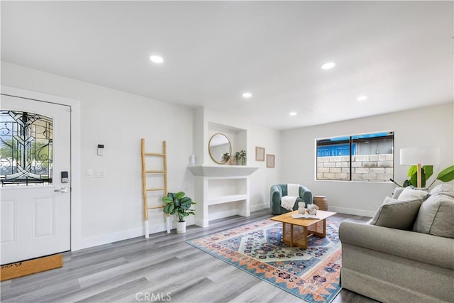 living area featuring baseboards, wood finished floors, and recessed lighting