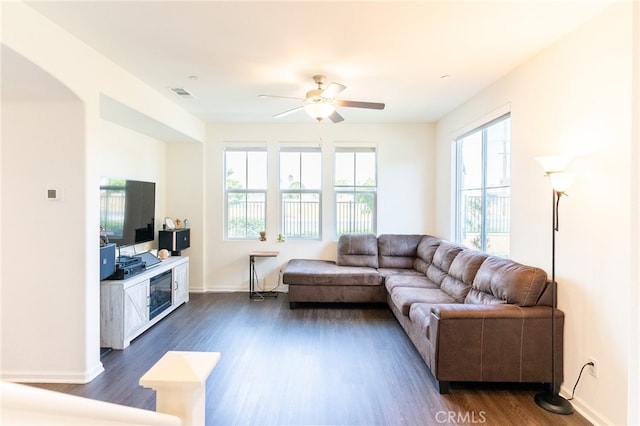 living room featuring dark wood-type flooring and ceiling fan