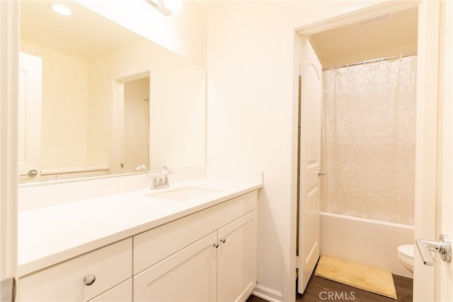 full bathroom featuring vanity, hardwood / wood-style floors, shower / bath combo, and toilet