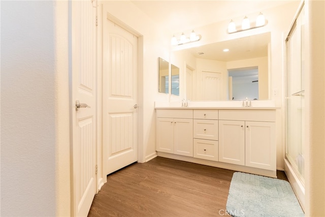 bathroom with vanity, an enclosed shower, and hardwood / wood-style flooring