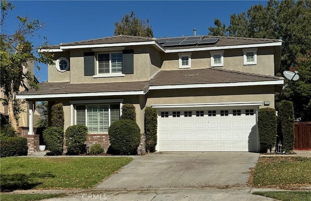 view of property featuring a garage, a front lawn, and solar panels