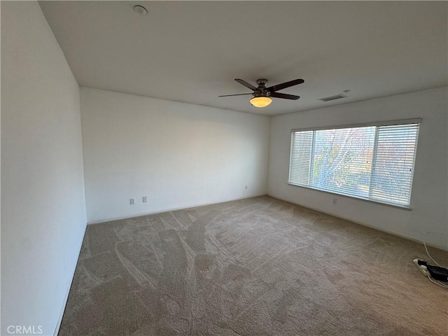 carpeted spare room with ceiling fan