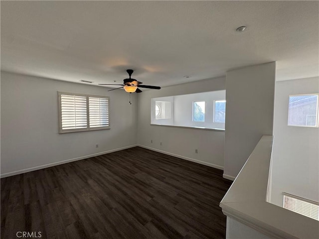 spare room featuring dark wood-type flooring and ceiling fan