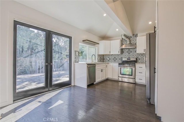 kitchen with lofted ceiling, white cabinetry, stainless steel appliances, and light countertops