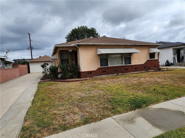 bungalow with an outdoor structure, a front yard, and a garage