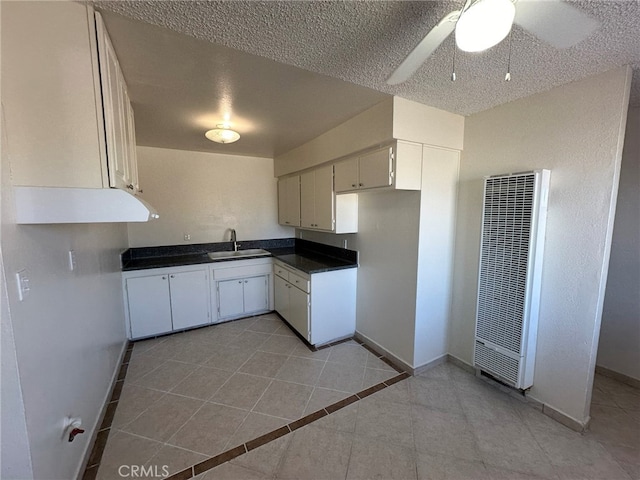 kitchen with sink, a textured ceiling, white cabinetry, ceiling fan, and light tile patterned floors