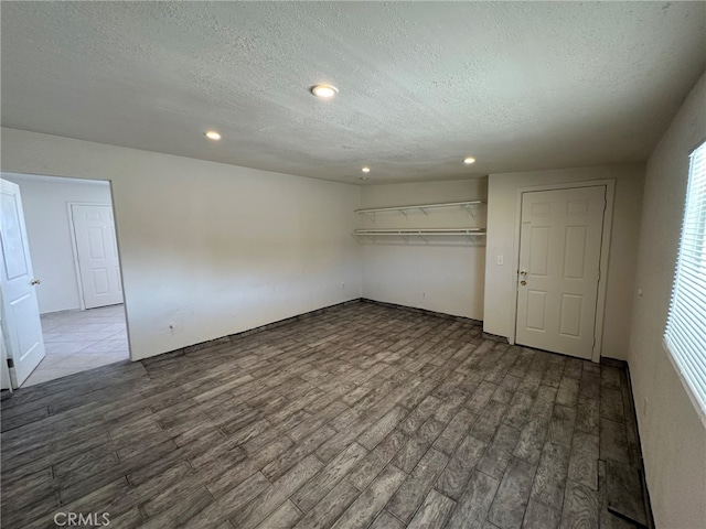 unfurnished bedroom featuring a closet, a textured ceiling, and dark wood-type flooring