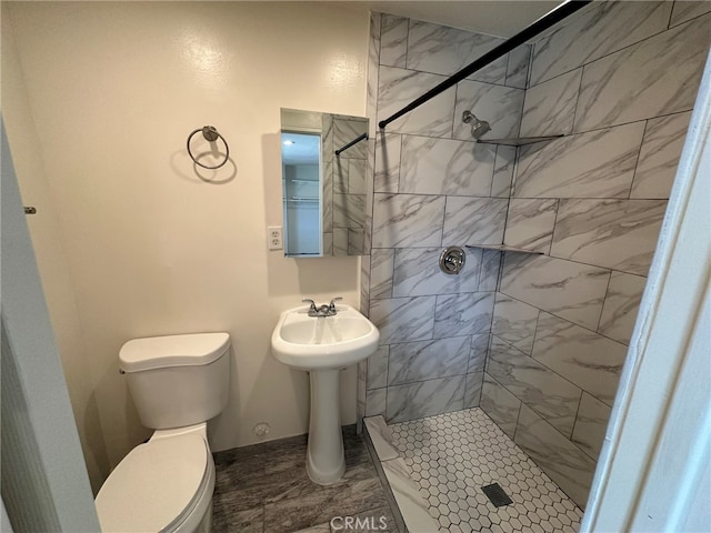 bathroom featuring a tile shower, toilet, and tile patterned floors