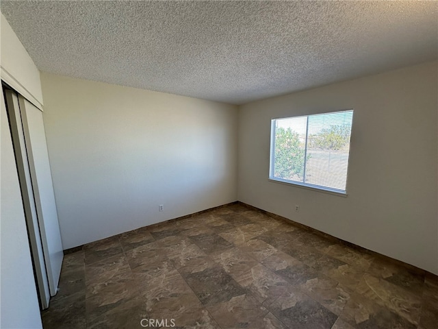 unfurnished bedroom with a textured ceiling and a closet