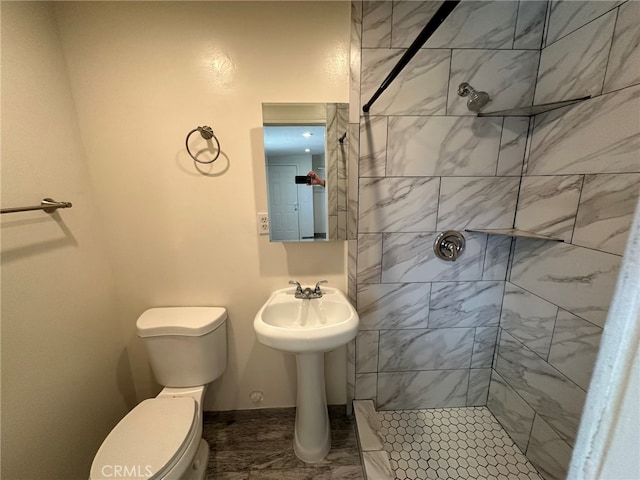 bathroom featuring tiled shower and toilet