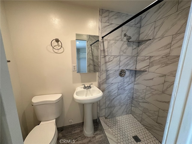 bathroom featuring a tile shower and toilet