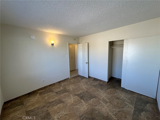 unfurnished bedroom featuring a textured ceiling and a closet