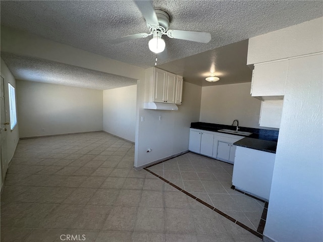 kitchen with white cabinets, a textured ceiling, sink, and ceiling fan